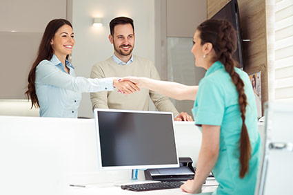 2 new patients shaking hands with receptionist